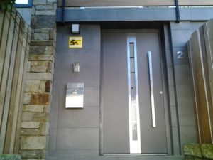 Puerta de Entrada Hörmann con acristalamiento central y tirador tipo barra de acero inoxidable en Galicia